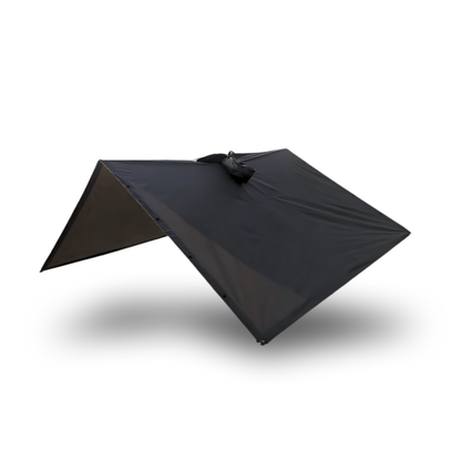 The Australian Trekshield poncho set up as an emergency ultralight tarp shelter using trekking poles, demonstrating a quick shelter solution for Camino pilgrims caught in unexpected weather between stops